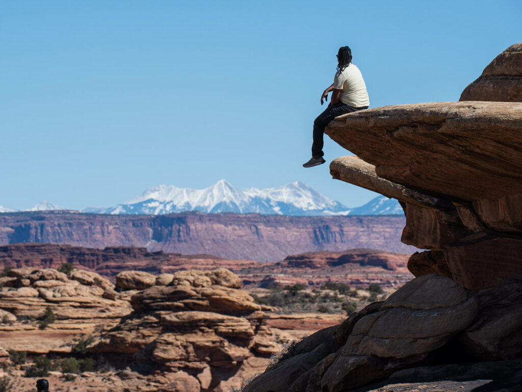 Sitting on top of a rock admiring the view of the La Sal Mountains from the needles district in Canyonlands National Park. wondering how many days do you need in Moab.