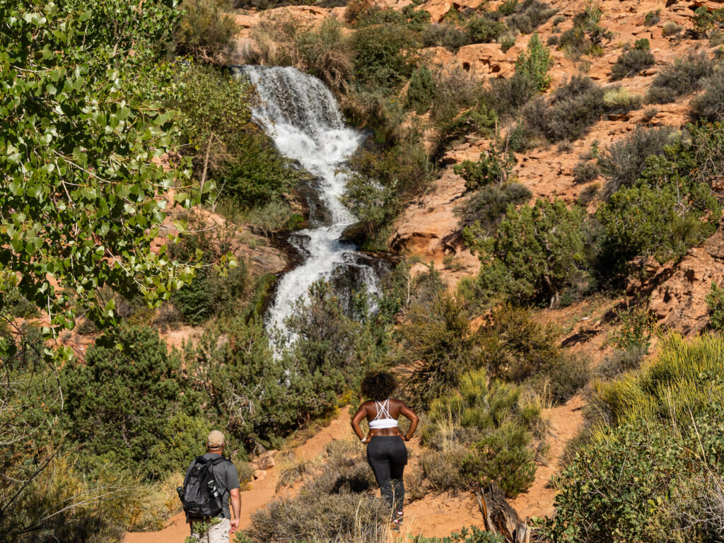 Rocio and gabe admiring Faux falls after hiking in Moab Utah