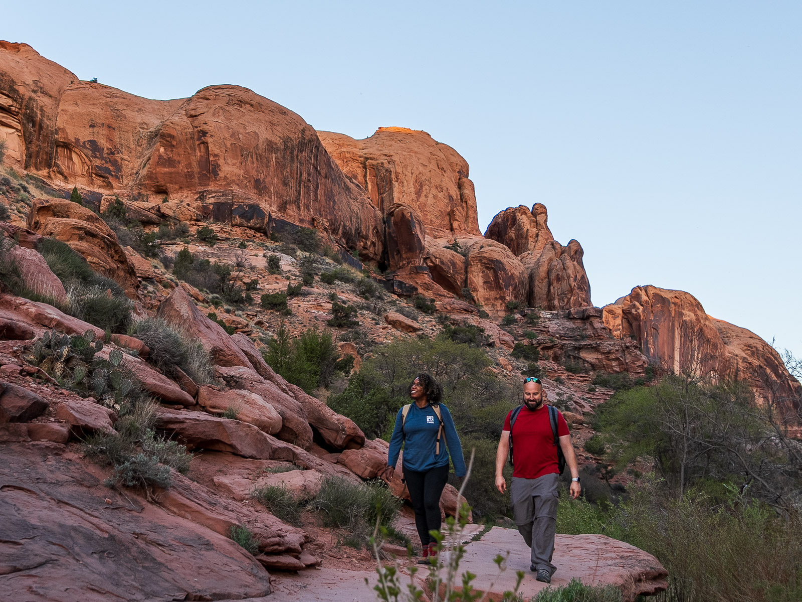 Rocio and gabe hiking in a red Rock Canyon on of the Best Easy Hikes Near Moab Utah