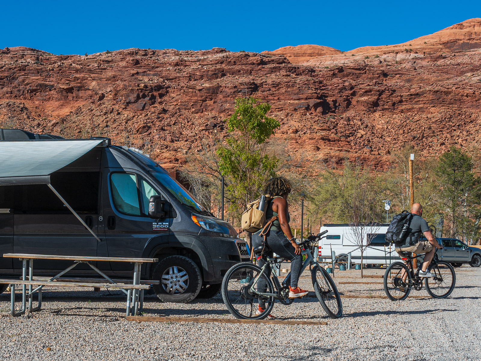 Rocio and gabe leaving their campsite riding bikes in Moab Utah